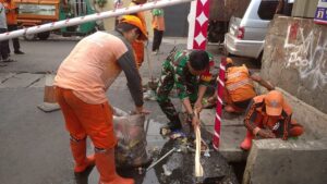 Semangat Peduli Lingkungan, Babinsa koramil 05/Tanah Abang Bantu Anggota PPSU Bersihkan Selokan
