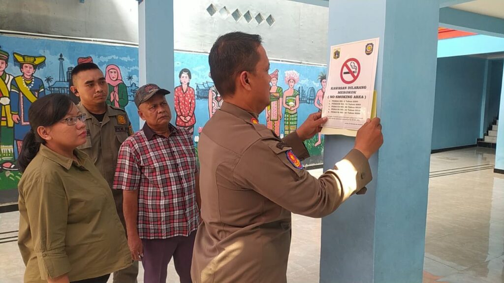 Satpol Kelurahan Kemayoran Pasang Stiker “Kawasan Dilarang Merokok” di Sejumlah Sekolah