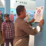 Satpol Kelurahan Kemayoran Pasang Stiker “Kawasan Dilarang Merokok” di Sejumlah Sekolah