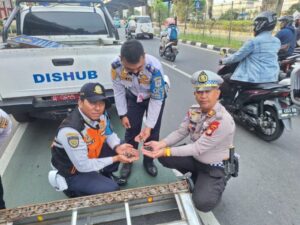 Polisi Lalu Lintas Jakarta Timur dan Petugas Gabungan Sterilisasi Ranjau Paku di Jalan DI Panjaitan