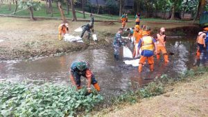 Babinsa Koramil Cipayung Bersinergi Bersihkan Kali Taman Bambu