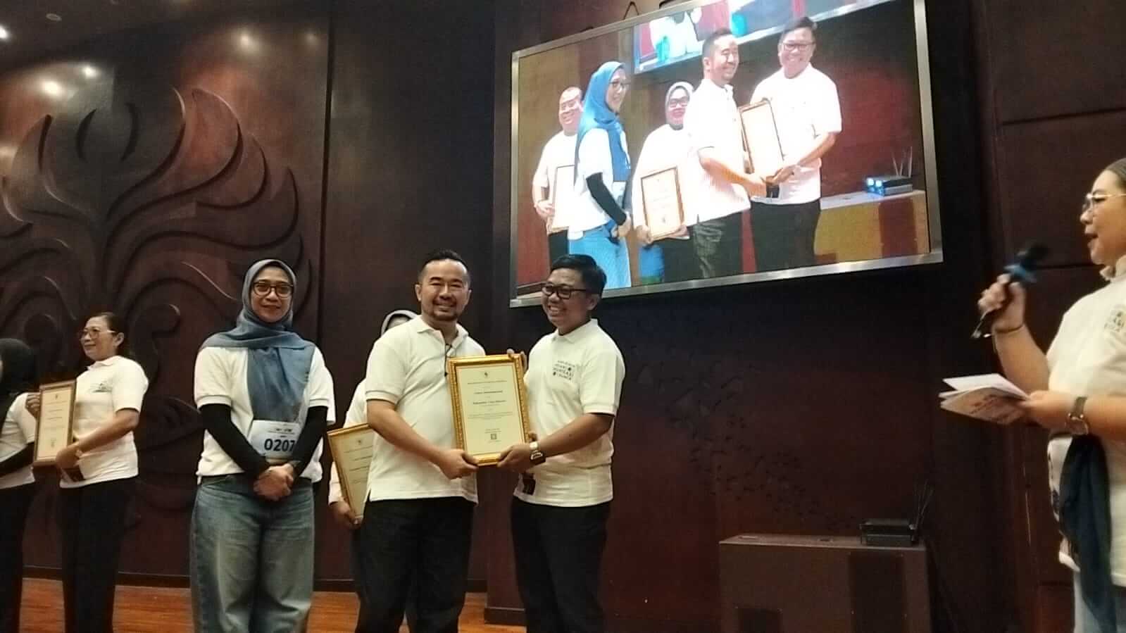 Plt. Dirjen P2P Kemenkes RI dr. Andi Saguni, MA. menyerahkan penghargaan Peringkat 1 Nasional Capaian Sepekan Mengejar Imunisasi kepada Kabupaten Toba pada Puncak Perayaan Pekan Imunisasi Dunia di FK UI Depok, 2 Mei 2026.