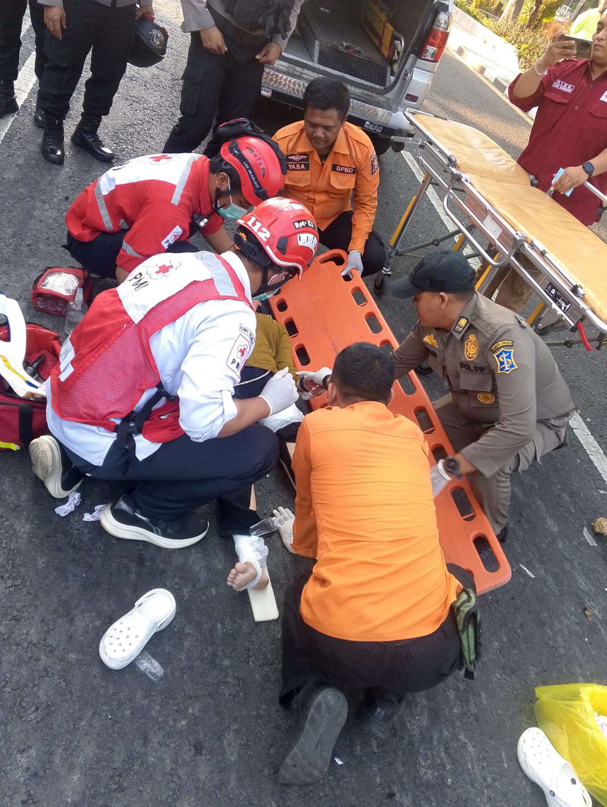 Foto: Petugas BPBD dan PMI mengevakuasi korban kecelakaan Honda Scoopy dan Toyota Innova di Jalan Diponegoro Surabaya.