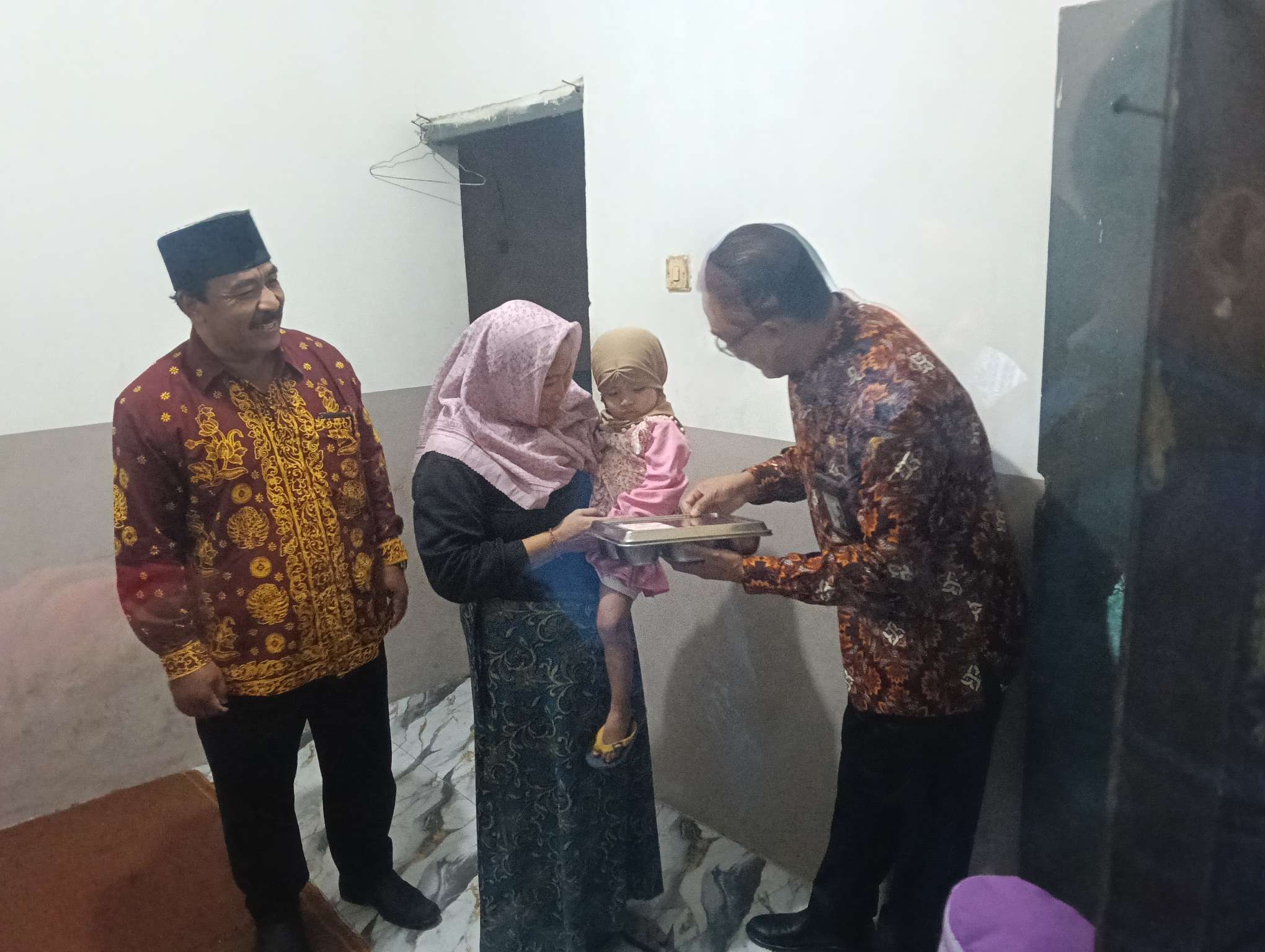 Foto: Kepala Perwakilan Kemendukbangga/BKKBN Jawa Timur Shodiqin menyerahkan bantuan Program GENTING kepada keluarga berisiko stunting pada puncak peringatan Harganas ke-33 Tahun 2026 di Pendopo Agung Kabupaten Malang.