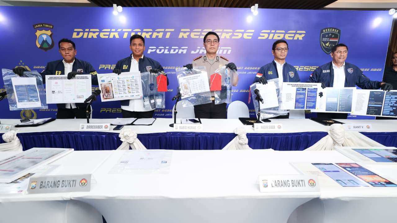 Foto: Petugas Ditressiber Polda Jawa Timur menunjukkan barang bukti dan tersangka kasus penipuan online bermodus penjualan emas murah dalam konferensi pers di Mapolda Jatim.