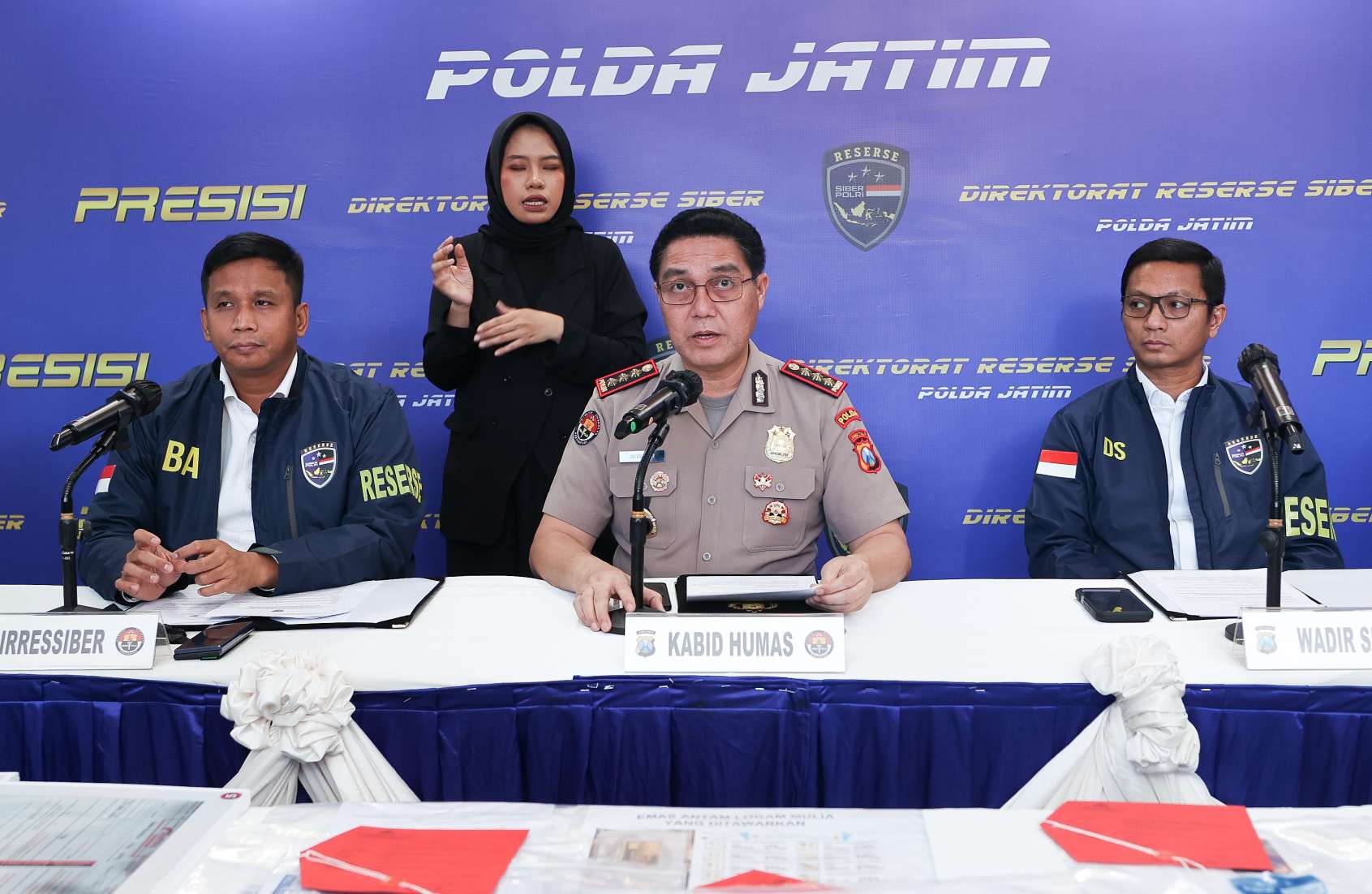 Foto: Petugas Ditressiber Polda Jawa Timur menunjukkan barang bukti dan tersangka kasus penipuan online bermodus penjualan emas murah dalam konferensi pers di Mapolda Jatim.