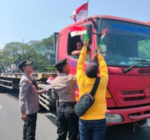 Sambut HUT ke-81 RI, Polres Pelabuhan Tanjung Perak Bagikan Bendera Merah Putih kepada Pengendara