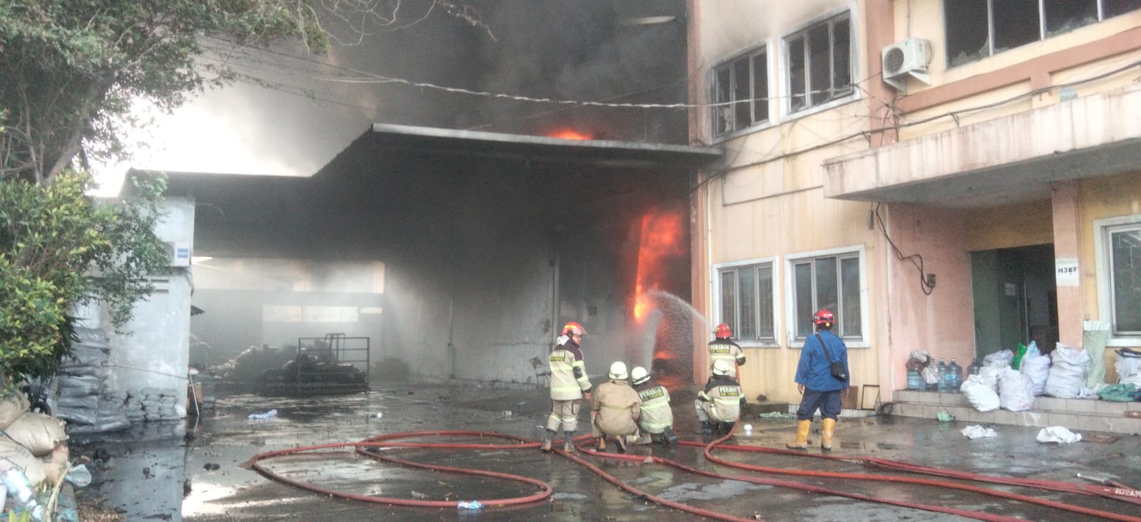Foto: Petugas pemadam kebakaran berjibaku memadamkan api yang membakar gudang di Komplek Pergudangan Sentra Kosambi, Kabupaten Tangerang, Minggu (9/8/2026). Tiga gudang dilaporkan terdampak dalam kebakaran tersebut.