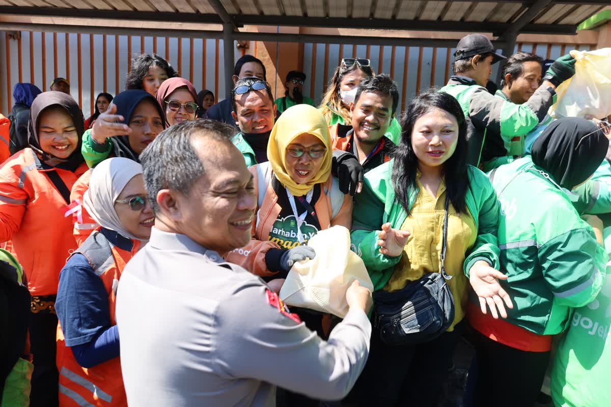 Foto: Kapolrestabes Surabaya Luthfie Sulistiawan menyerahkan paket sembako kepada driver ojek online dalam kegiatan bakti sosial di Surabaya